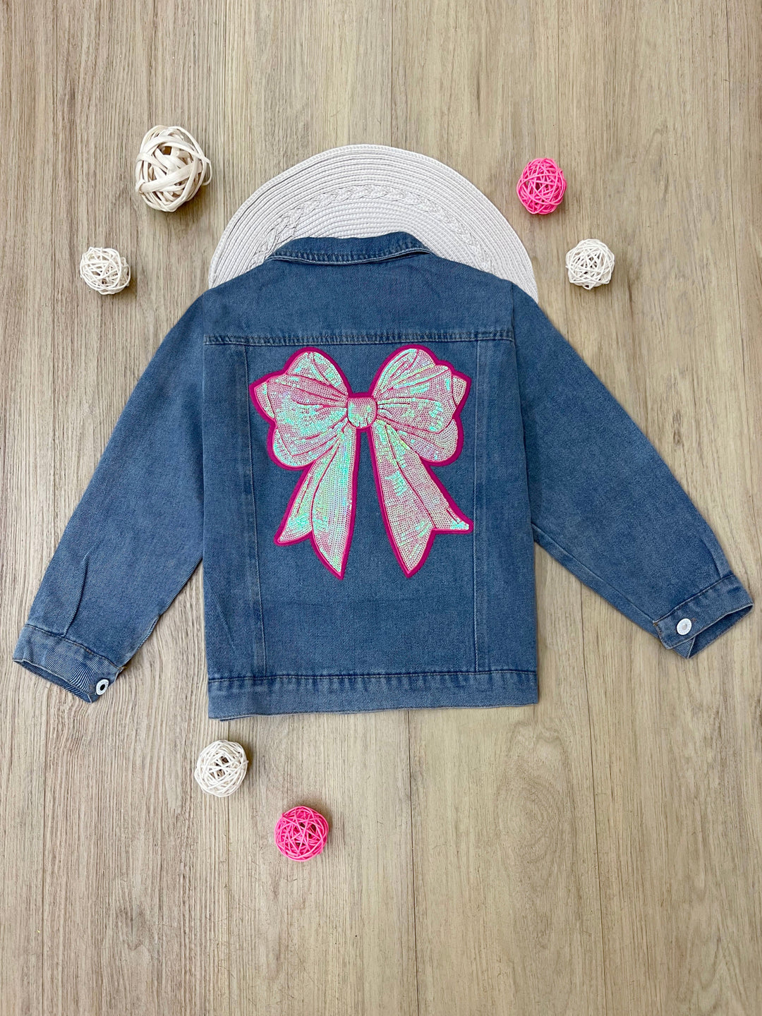 Close up of large pink sequin bow on girls denim jacket
