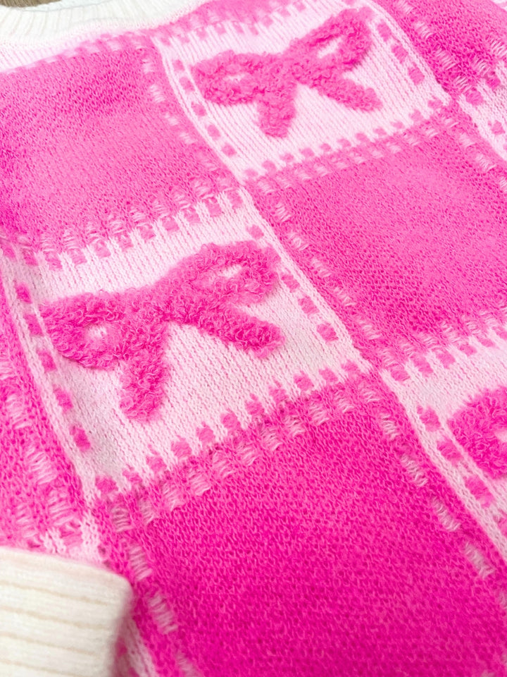 Close up of pink bow patchwork knit sweater fabric texture
