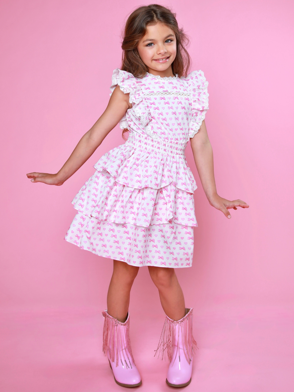 Girls pink bow print smocked dress with ruffle sleeves and tiered skirt