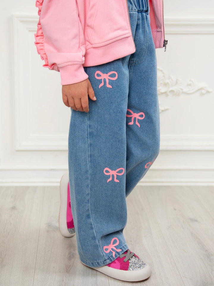 Girl wearing light wash wide leg denim jeans with pink bow details and elastic waistband