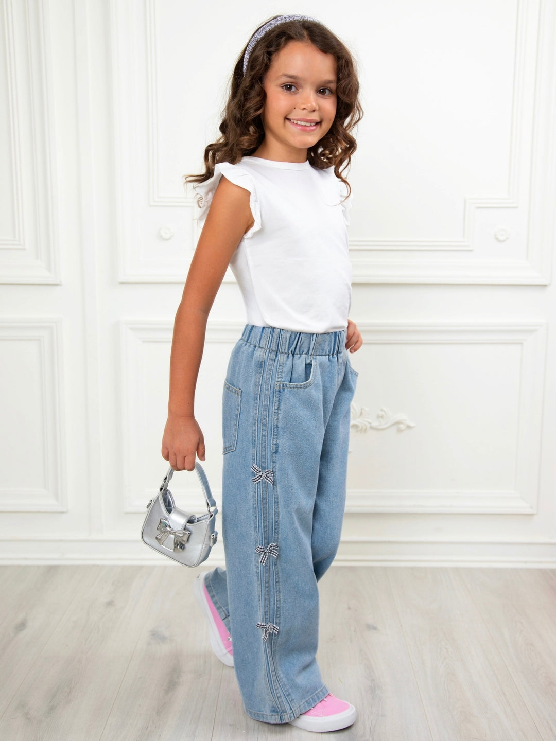Trendy girls denim jeans featuring pearl bow accents on the side
