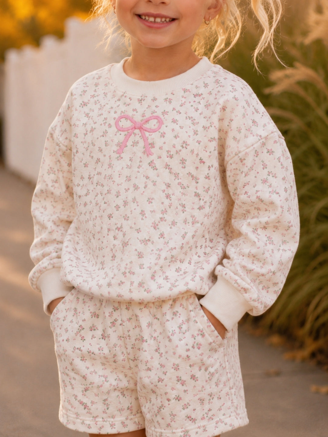 Girls cozy floral outfit with embroidered bow detail.