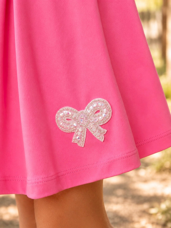 Bright pink girls athletic outfit with pleated skort