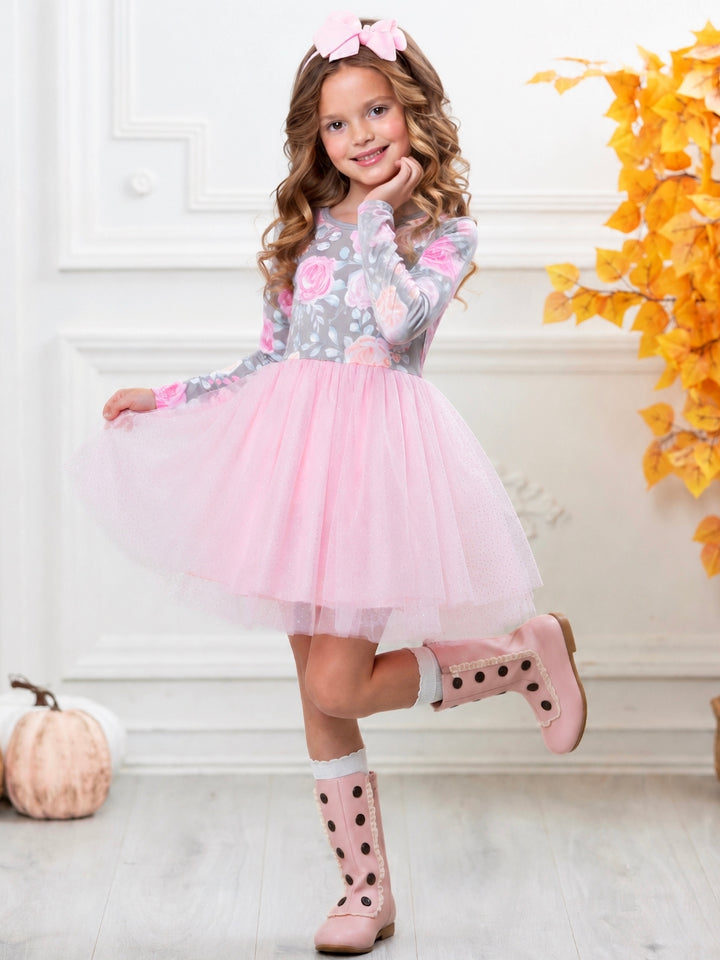 Girl wearing a floral long sleeve dress with a pink glitter tulle skirt.