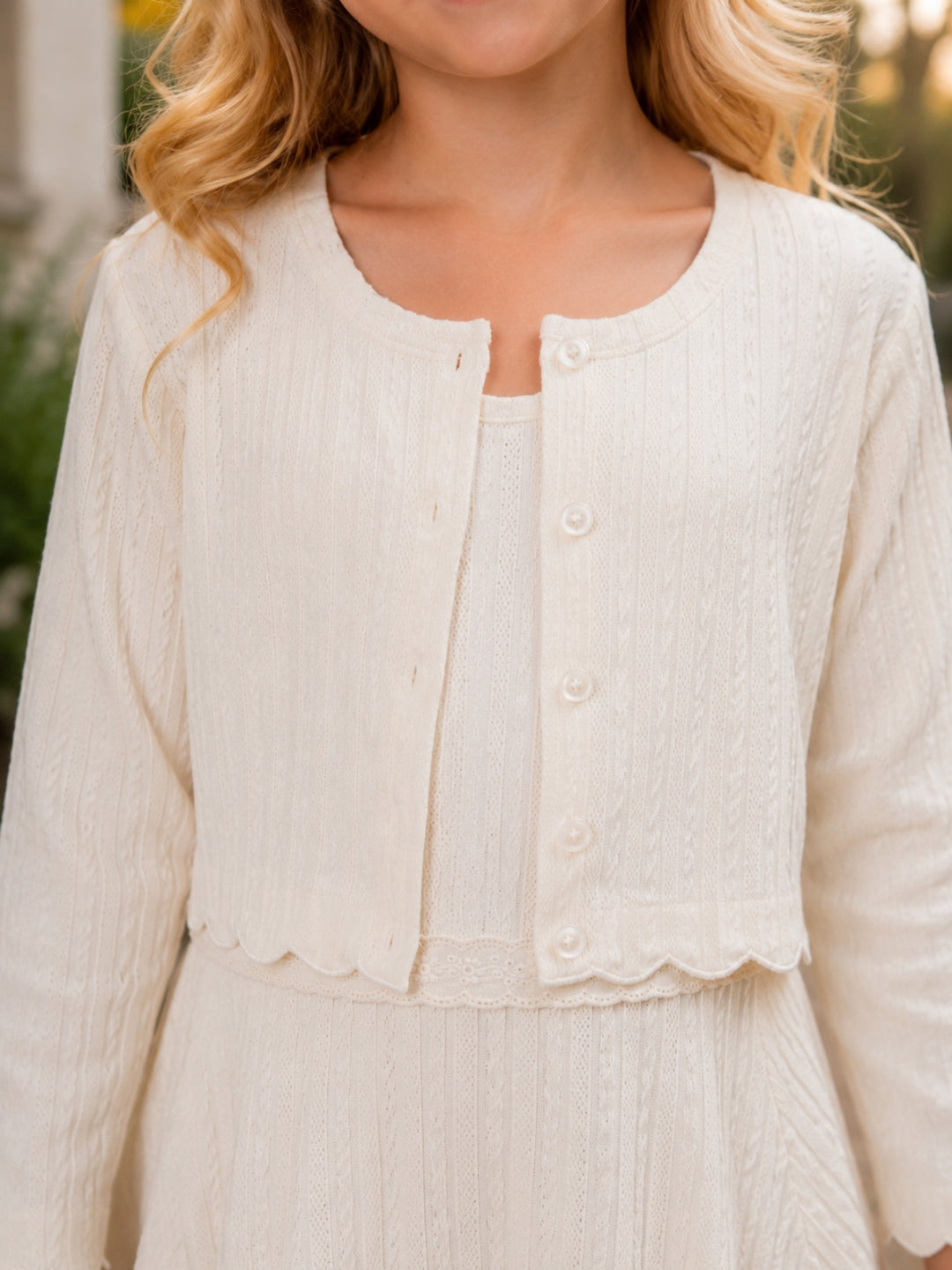 Girls ivory dress and cardigan set with scalloped trim.