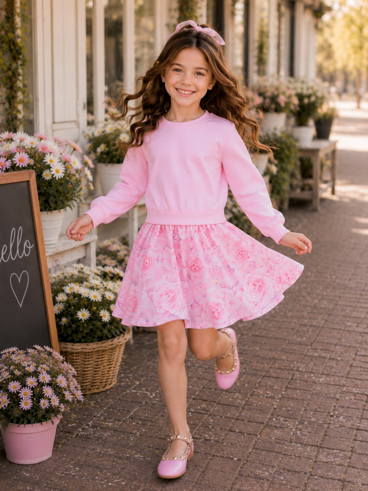 Girl wearing a pink floral long sleeve twirl dress with full skirt.