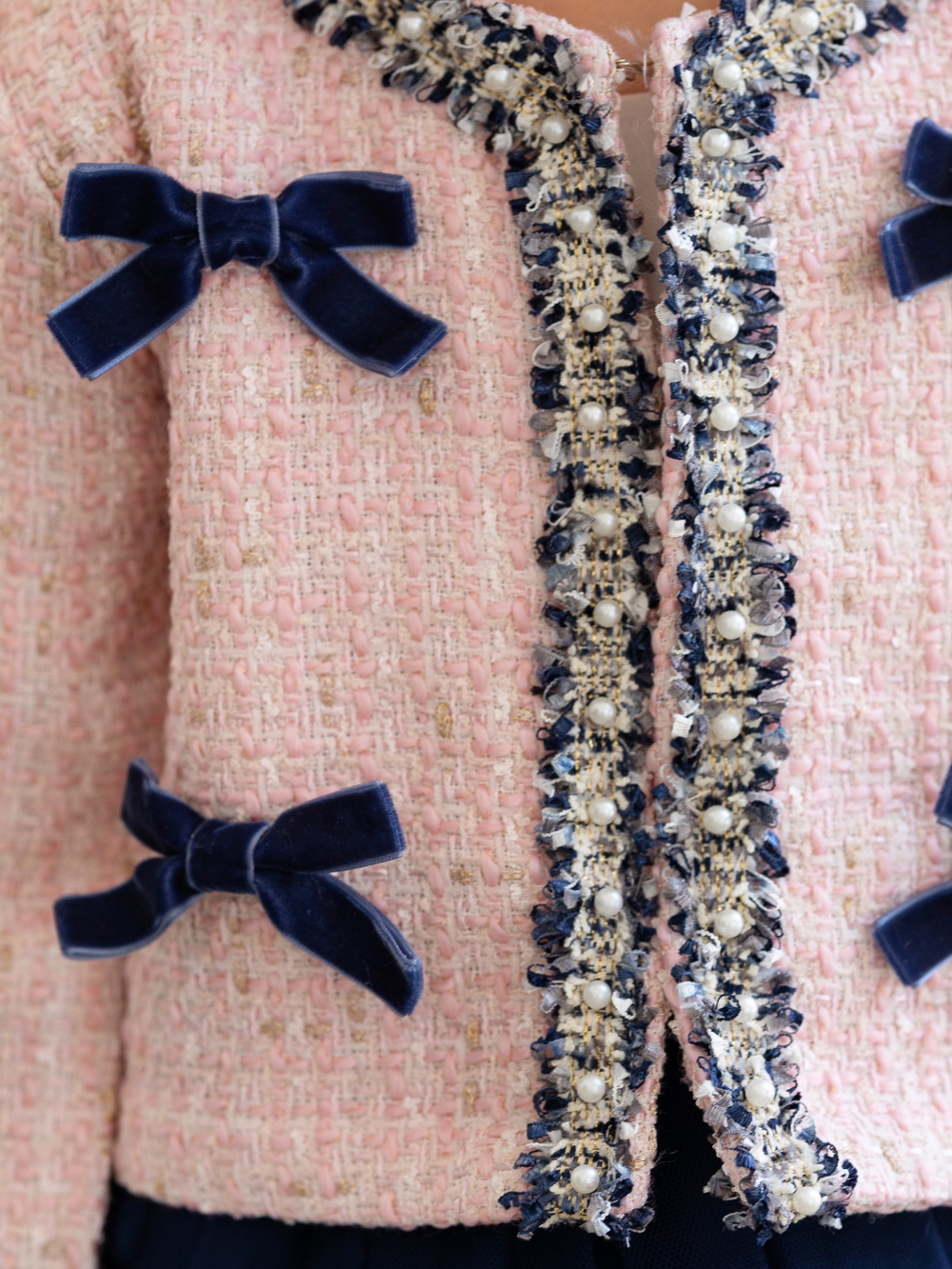 Girls tweed jacket with navy elegant bow accents and tweed material.