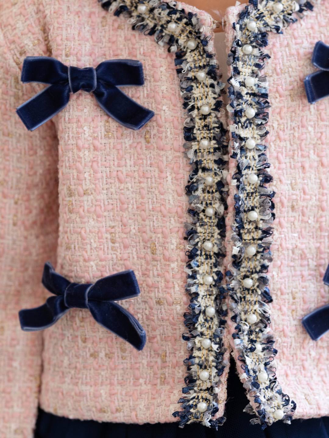 Girls tweed jacket with navy elegant bow accents and tweed material.