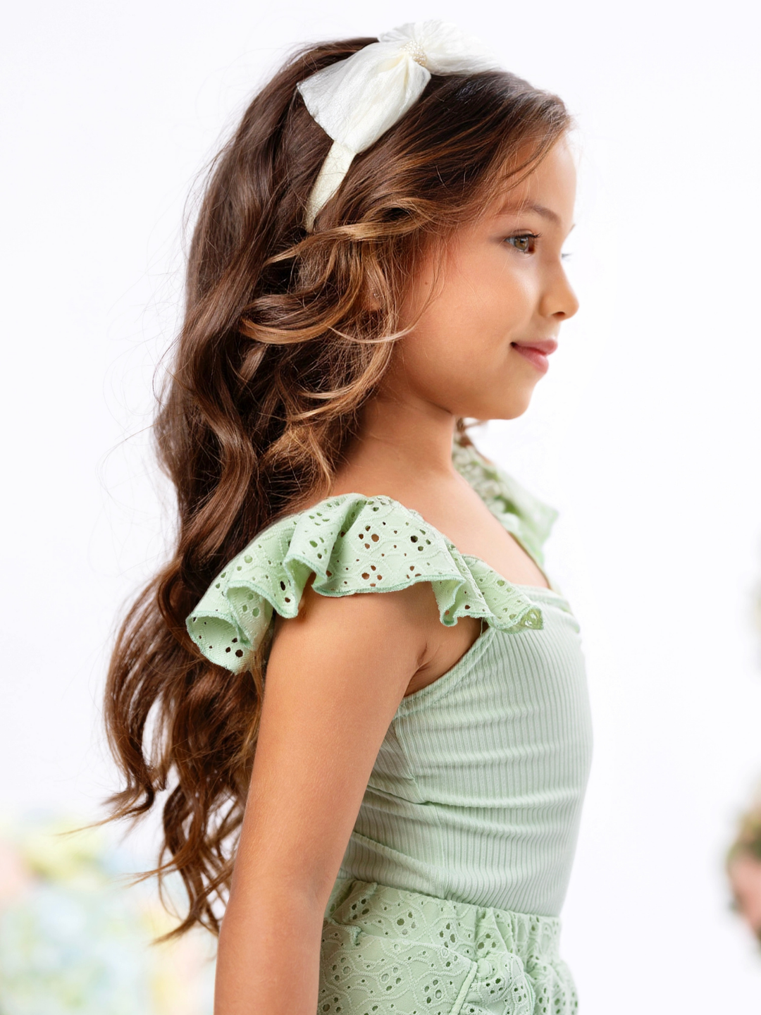Girls casual summer outfit with sage green ruffle top and eyelet shorts