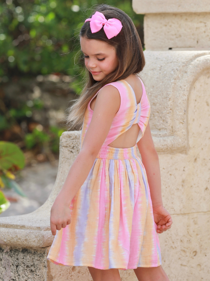 girl wearing pastel stripe summer dress with open back detail