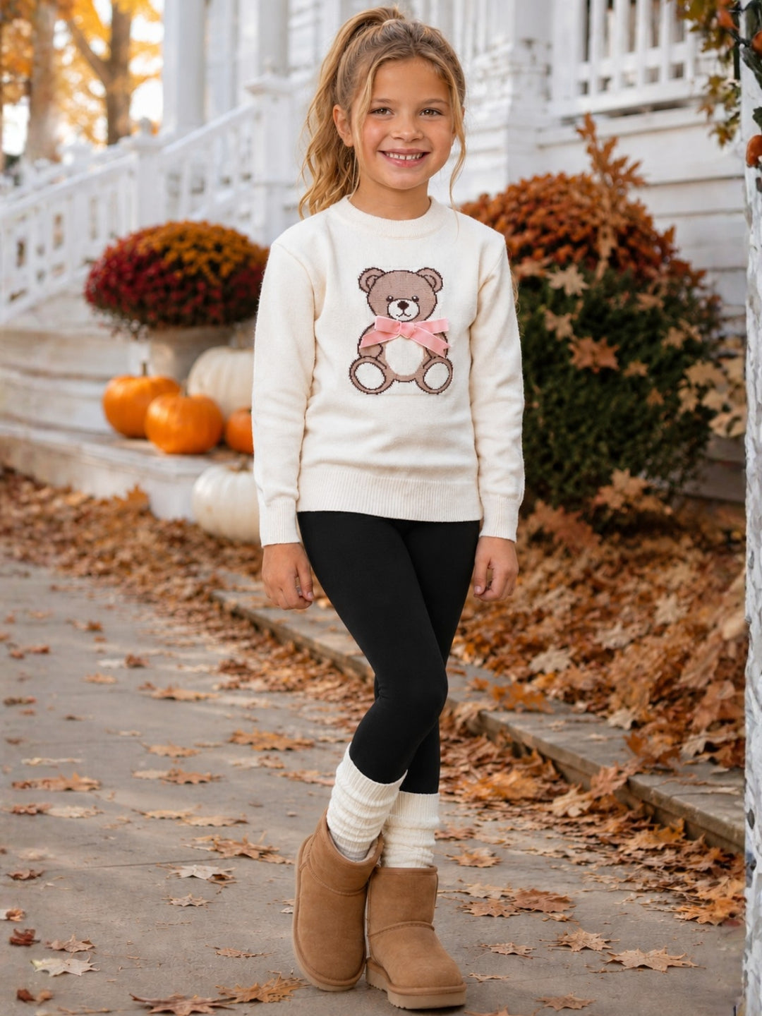 Girls fall sweater paired with leggings.